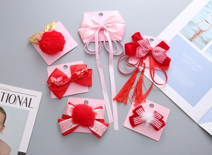 Dettaglio di fermagli per capelli del Capodanno Cinese con nappe rosse e pompon velluto