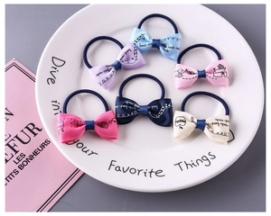 Detailed view of colorful girls' floral bow hair ties with cartoon prints in a tray