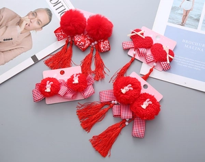 Dettagli dei fermagli rossi per capelli del Capodanno Cinese con nappe e pompon per bimbe