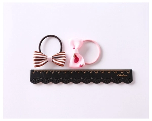 Detailed view of striped and strawberry pattern bow hair ties with a scale showing 4.5cm width