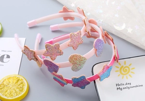 Dettaglio di cerchietti glitterati a stella e cuore per bambine con colori sfumati