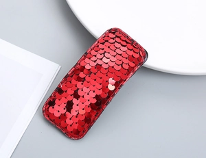 Detailed view of a red sequined rectangular hair clip with shiny metallic reflections