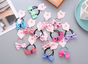 Detailed set of floral bow hair ties for girls on cute pink bear cardboard display