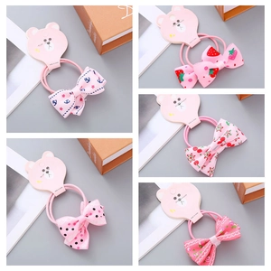 Detail of five assorted pink ribbon bow hair ties with strawberry and cherry prints on card