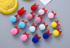 Detail view of colorful fluffy pom-pom hair clips with glittery bows for children