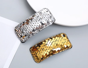 Detailed view of silver and gold sequin square hair clips with metallic shimmer and black base