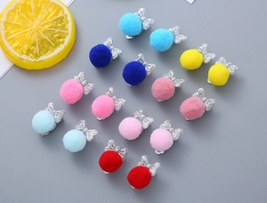 Flat lay of colorful glitter bow hair clips with soft pom poms for girls and children