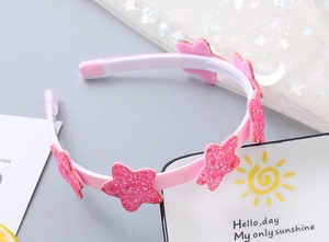 Dettaglio di cerchietto rosa per bambina con stelle glitterate e denti antiscivolo