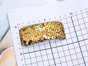Detail showing measurement of 7cm gold sequin rectangular hair clip on scale paper