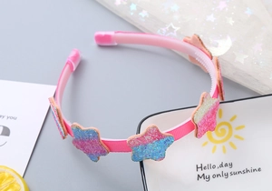Dettaglio cerchietto rosa per bambina con stelle glitterate e design con denti interni
