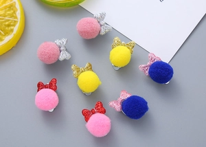 Detail view of colorful faux fur balls and glitter bow hair clips for girls