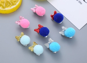 Detail of 8pcs kids plush pompom and glitter bow ear clips set on grey background