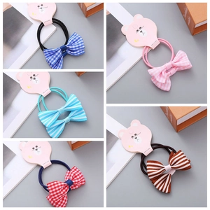 Close-up of 5-piece girls' bow hair ties set featuring plaid and striped patterns