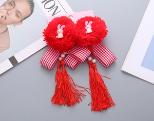 Dettaglio di fermagli per capelli rossi in peluche con conigli, nappe e perle da bimba