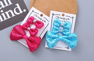 Detailansicht des dreiteiligen Glitzer-Schleifen-Haarspangen-Sets in Pink und Blau