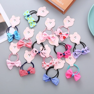 Set of colorful handmade bow hair ties with floral prints and cartoon bear packaging