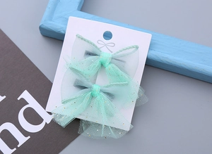 Detail view of mint green mesh hair clips with gold glitter for kids princess hair styling