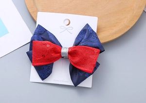 Dettaglio del fermaglio per capelli vintage blu e rosso con paillettes su carta bianca