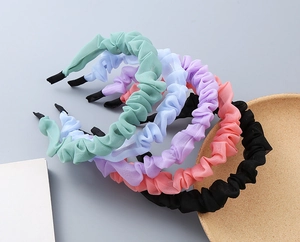 Dettaglio di cerchietti in chiffon a pieghe in verde menta, blu, viola, rosa e nero