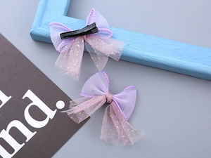 Detail of two-piece purple tulle bow hair clips with gold glitter dots and alligator clips