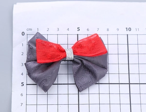 Dettaglio del fiocco per capelli a doppio strato con jacquard vintage e paillettes rosse