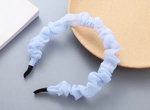 Dettaglio del cerchietto in chiffon plissettato azzurro con punte protettive nere