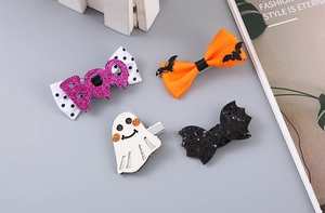 Detailed view of Halloween hair clips featuring glitter bows, ghosts and bat designs