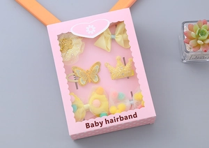 Close-up of yellow 6-piece baby hair clip set in a decorative pink window gift box
