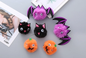 Detail of plush Halloween clips featuring bats, pumpkins, and cats for festive party hair styling