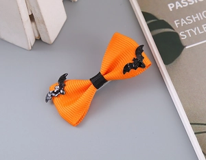 Detail of orange grosgrain bow clip with black glittery bats for Halloween styling
