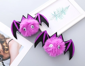 Detail of plush purple bat hair clips with googly eyes and felt wings for Halloween party