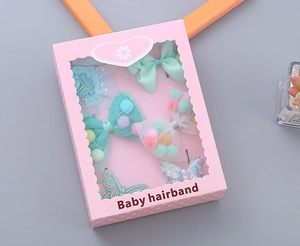 Detail of pink gift box with handmade ribbon bows and glitter butterfly hair clips