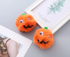 Detail of plush orange pumpkin hair clips with googly eyes for Halloween party