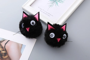 Detailed view of two cute black plush cat hair clips with pink ears for Halloween