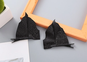 Detail view of black glittery bat wing hair clips with secure metal duckbill backing