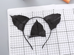 Detail showing dimensions of black glitter bat ear headband and clips on scale paper