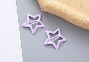 Détail de deux barrettes en forme d'étoile couleur lavande avec design évidé élégant