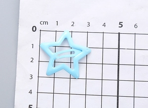 Vue détaillée d'une pince à cheveux étoile bleu ciel de 3 cm sur une échelle de mesure