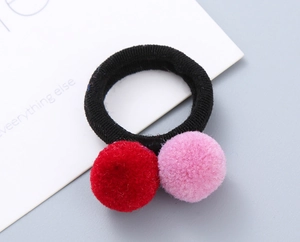 Detail of red and pink fluffy plush balls on high-elasticity black hair ties