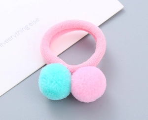Detail of pink hair tie with soft pink and mint green pom-poms for girls