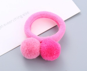 Detailed macro view of vibrant pink plush poms on a high-elasticity knitted hair tie