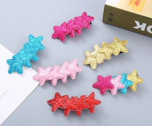 Close-up of six glittery star hair clips in assorted colors for girls' hair styling