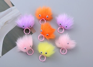 Detail of colorful plush monster rings with adjustable plastic bands and googly eyes