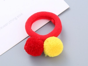 Detail of soft red and yellow pom-pom hair ties with high elasticity for girls