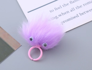 Detail of cute purple plush monster ring with fuzzy texture and pink plastic band