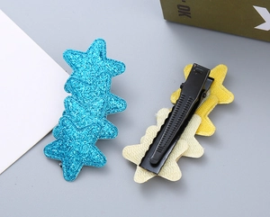 Detailed macro view showing the blue glitter star and black metal alligator clip structure