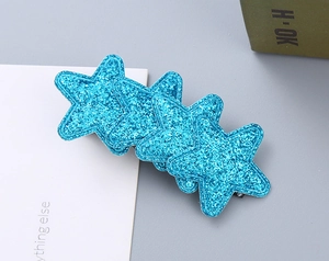 Macro shot of blue glitter star hair clip showing detailed sequins on silver duckbill clip