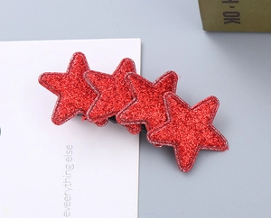 Close-up of four glittery red star hair clips arranged in a row with a sleek metal duckbill clip