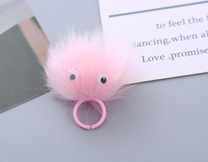 Close-up of pink fuzzy monster ring with googly eyes for kids playful plush accessory