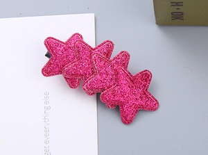 Detail of pink glitter star hair clips with shimmering finish for festive girls styling
